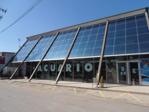 Fachada acristalada del Acuario de O Grove con entrada principal y estructura inclinada.